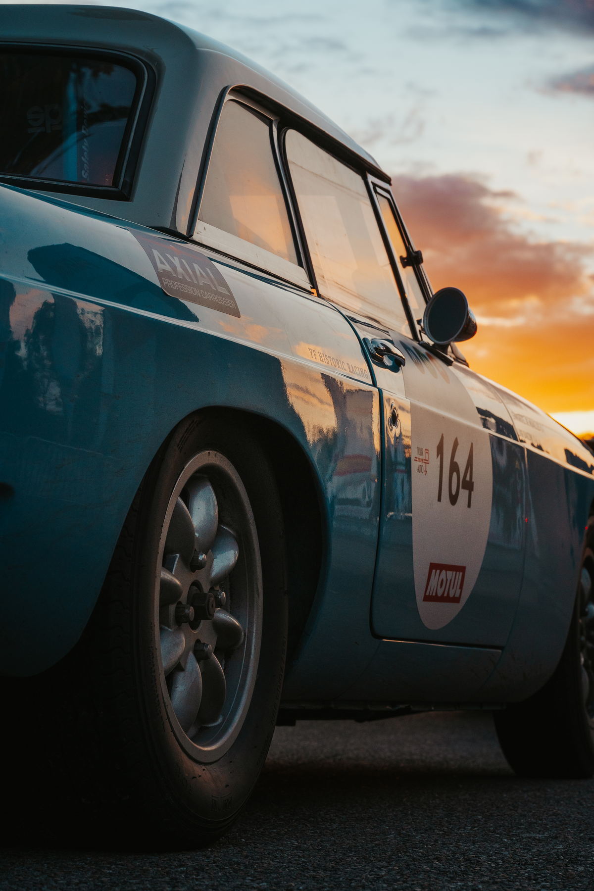 Porsche 911 de course bleue à l'arrêt, ciel de fin de journée
